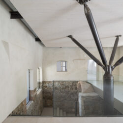 Landgut Gruber_zum Keller Landgut Gruber_Eingangshalle im Erdgeschoss_die Unterkonstruktion der Wohnplattform als konstruktive Verklammerung des Altbestandes